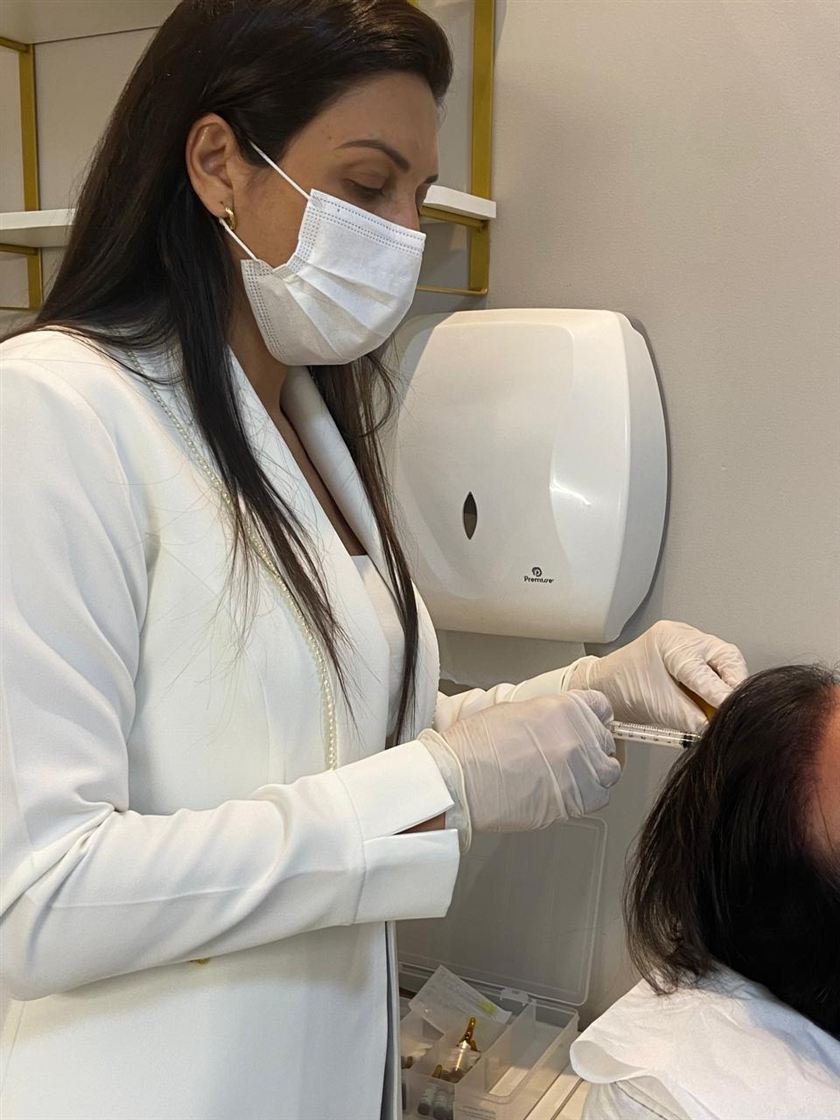 Dra. Ana Flávia realizando atendimento de tricologia no couro cabeludo de uma paciente