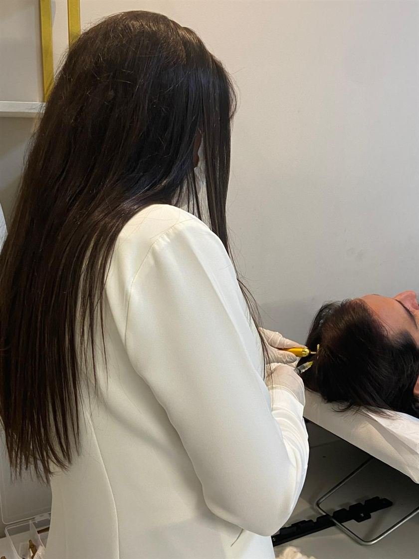 Dra. Ana Flávia atendendo uma paciente deitada na maca